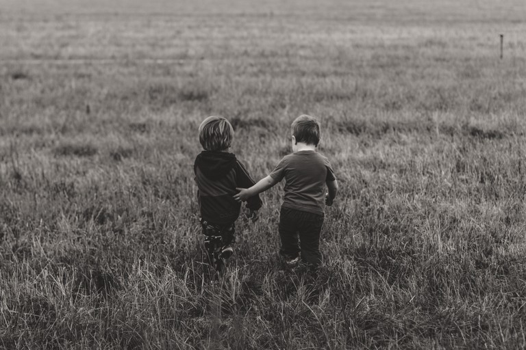 Download Our Touching Black and White Wallpaper of Kids in a Field