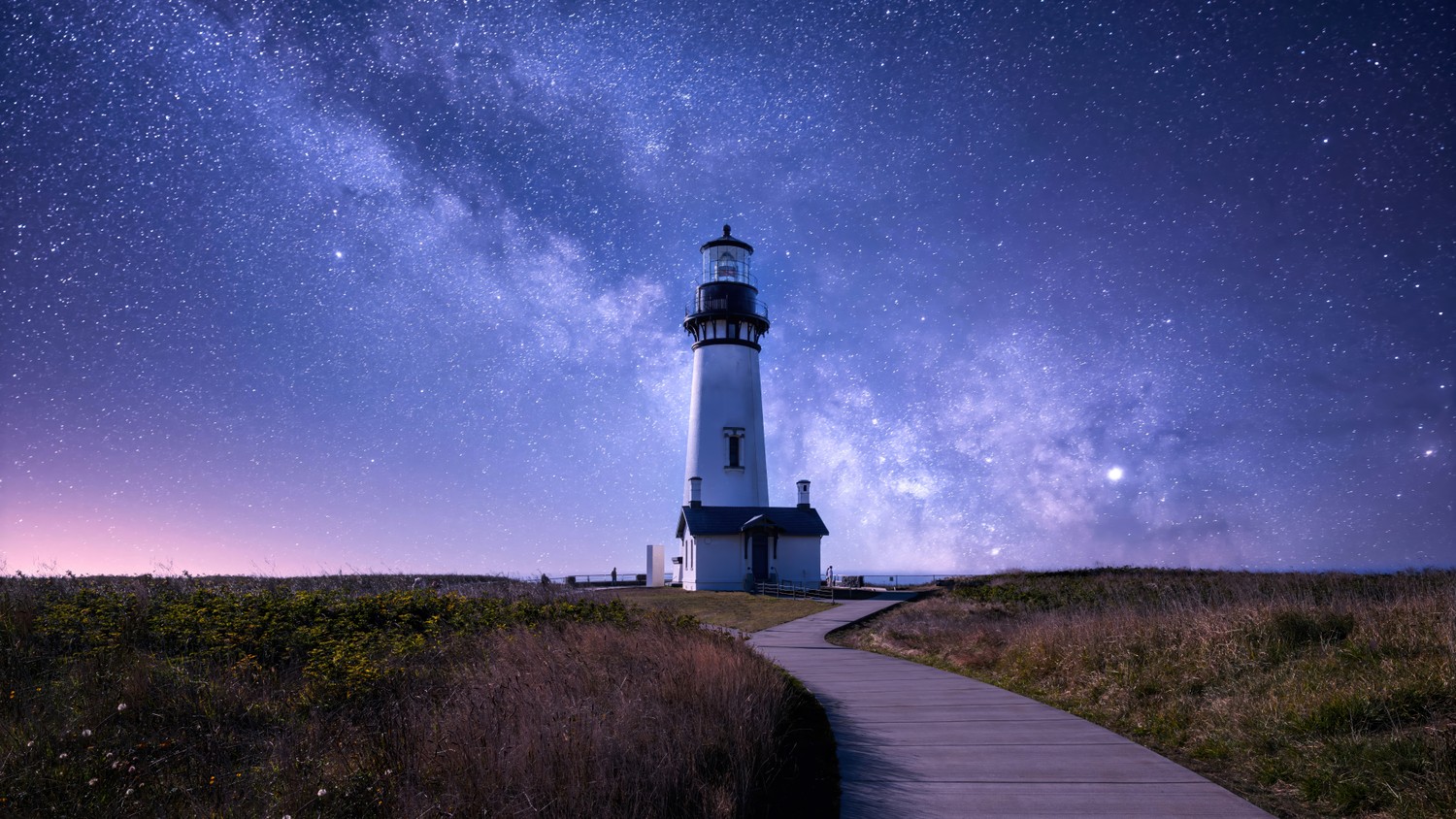 Breathtaking Night Sky Wallpaper Featuring a Lighthouse