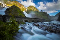 Explore the Majestic Waterfall and Scenic Bridge Wallpaper