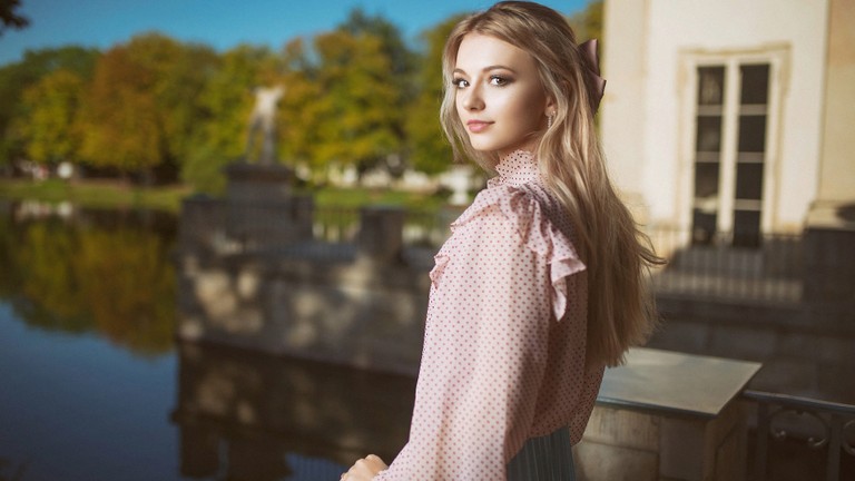 Beautiful Young Woman in Elegant Outfit by the Water