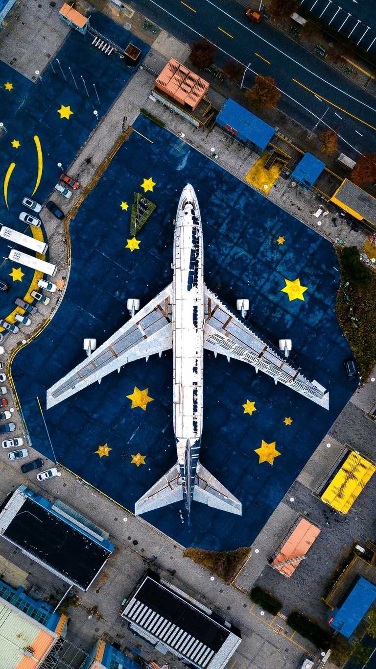 Explore This Unique Aerial View of an Airplane in Urban Space