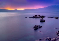 Paysage Maritime Éblouissant avec Côte Rocheuse et Ciel Violet